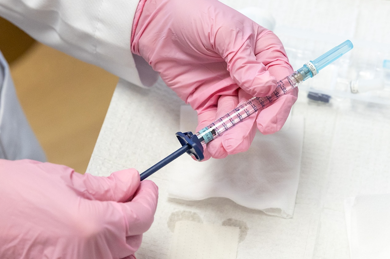 The hands of a provider at ThrIVe Wheeling, wearing surgical gloves, holding a syringe of fillers near you in Washington, PA.